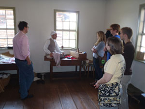 Students of HIS 5585: Historic Preservation listen to a tailor discuss his work at Old Salem, Single Brothers House.