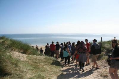 group of students walking toward a beach